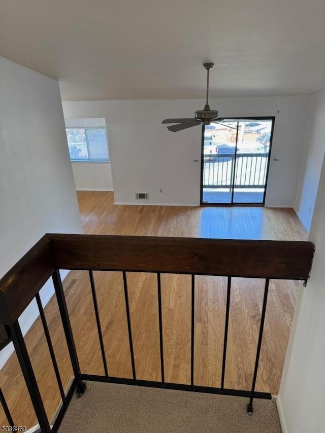 staircase featuring visible vents, ceiling fan, and wood finished floors