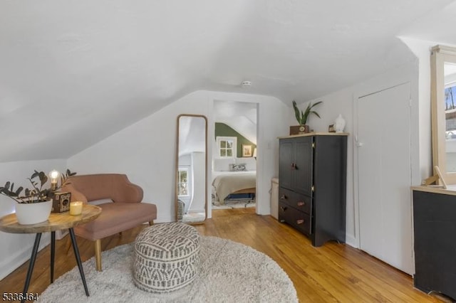 living area with vaulted ceiling and light wood-type flooring