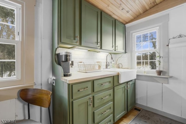 interior space featuring sink, backsplash, wooden ceiling, and green cabinets