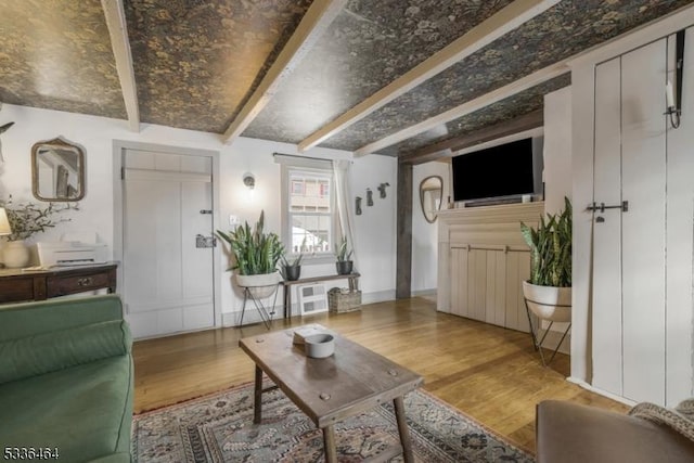 living room with beam ceiling and light hardwood / wood-style flooring