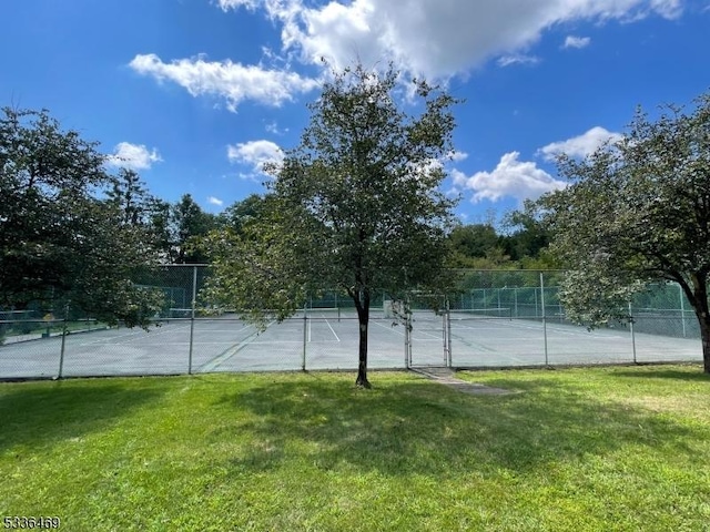 view of sport court featuring a lawn