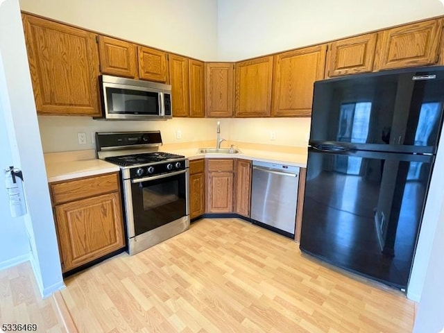 kitchen featuring sink, light hardwood / wood-style floors, and appliances with stainless steel finishes