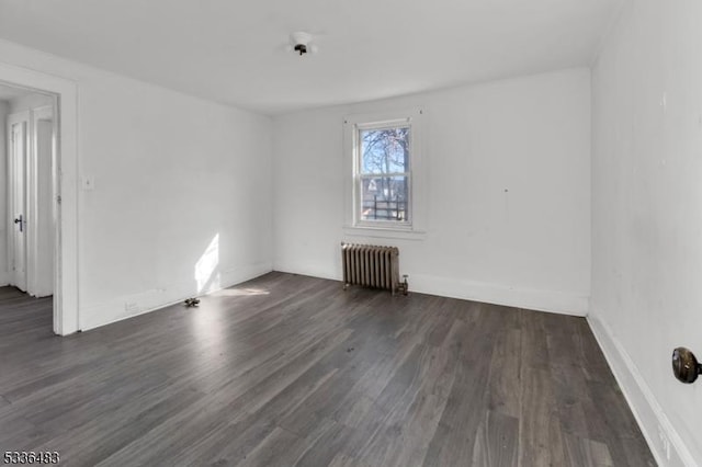 unfurnished room with radiator and dark hardwood / wood-style floors