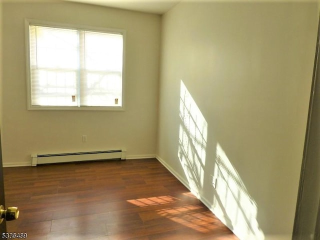 empty room with baseboards, baseboard heating, and dark wood-style flooring