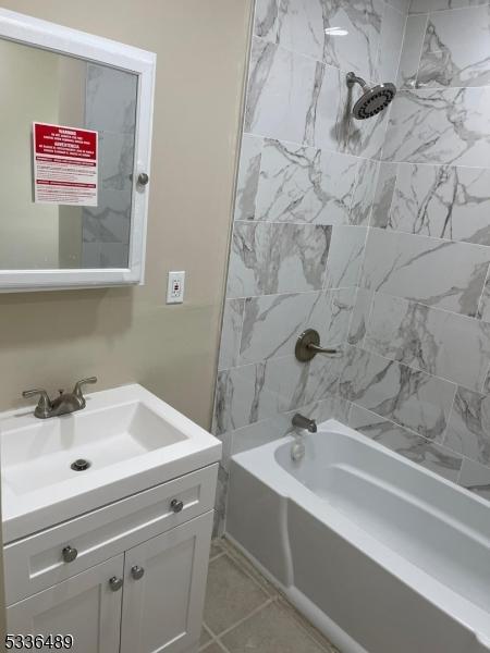 full bath featuring tile patterned flooring, bathing tub / shower combination, and vanity