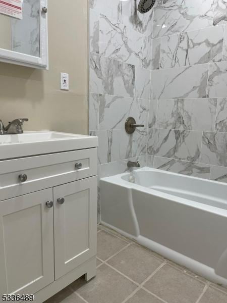 bathroom featuring tile patterned flooring, washtub / shower combination, and vanity