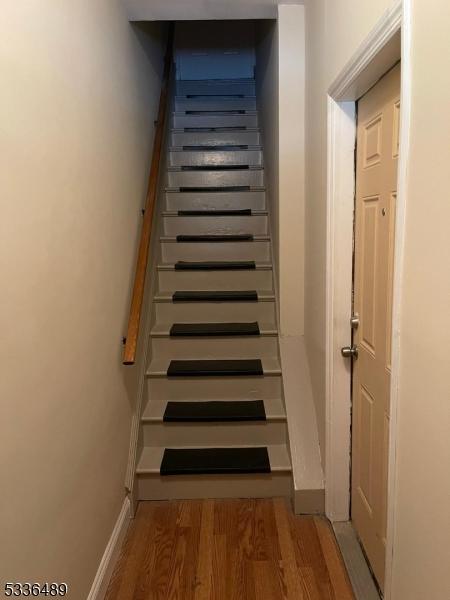 stairs with wood finished floors and baseboards