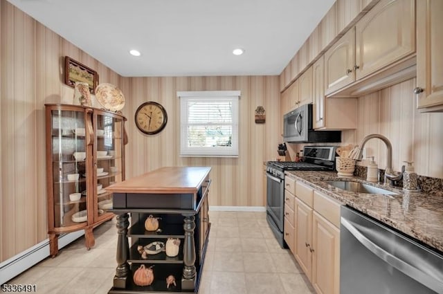 kitchen with sink, stainless steel appliances, dark stone counters, and light brown cabinets