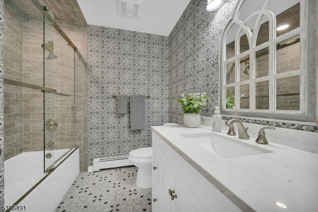 full bathroom with toilet, shower / bath combination with glass door, tile walls, baseboard heating, and vanity