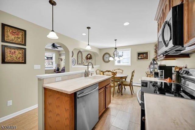 kitchen featuring sink, hanging light fixtures, a center island with sink, appliances with stainless steel finishes, and a wealth of natural light