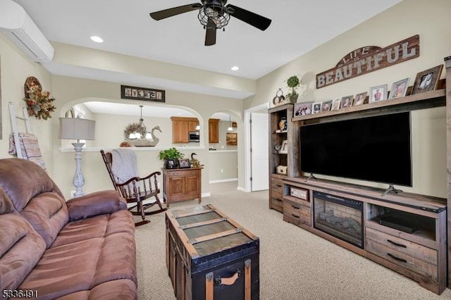 carpeted living room with ceiling fan and a wall mounted AC