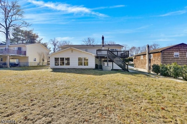 rear view of house with a wooden deck and a yard