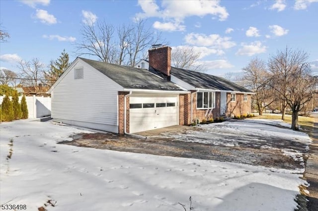 view of snow covered exterior with a garage