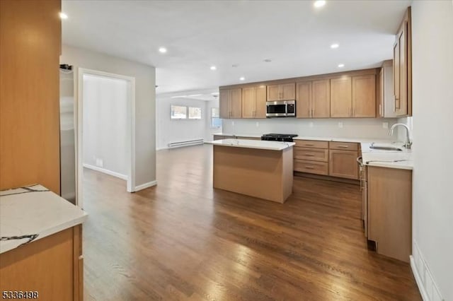 kitchen featuring baseboard heating, dark hardwood / wood-style flooring, sink, and a kitchen island