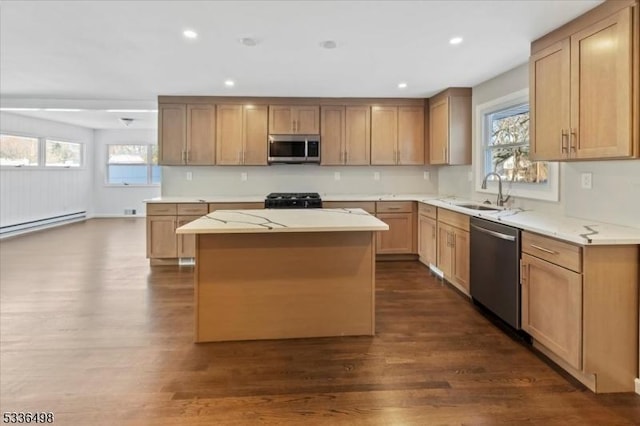 kitchen with sink, a baseboard heating unit, stainless steel appliances, dark hardwood / wood-style floors, and a center island