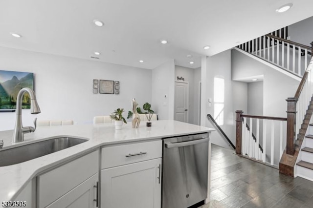 kitchen with dishwasher, sink, white cabinets, dark hardwood / wood-style flooring, and light stone countertops