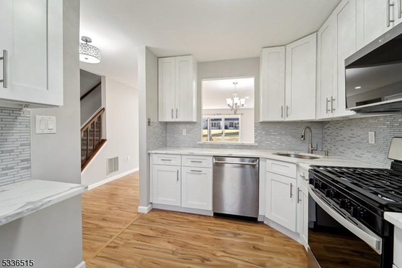 kitchen with white cabinetry, appliances with stainless steel finishes, sink, and light wood-type flooring