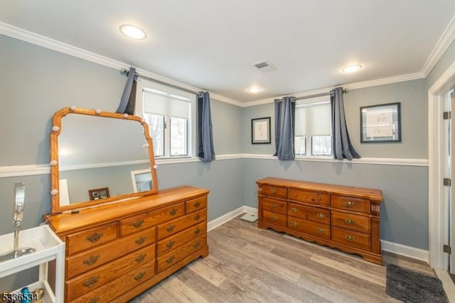 bedroom with ornamental molding and light hardwood / wood-style flooring