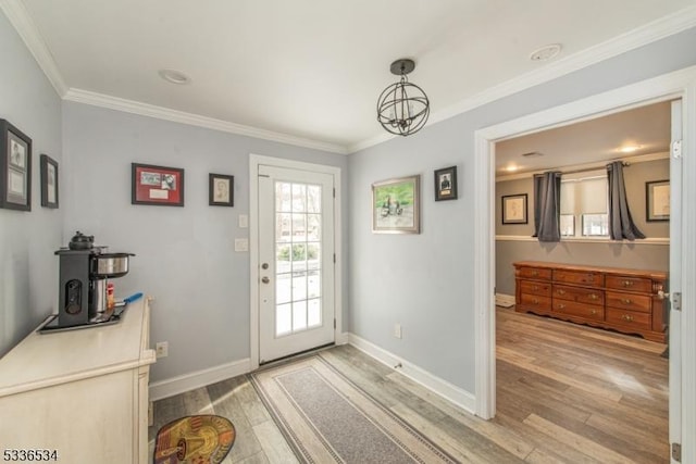 doorway to outside with an inviting chandelier, hardwood / wood-style floors, and ornamental molding