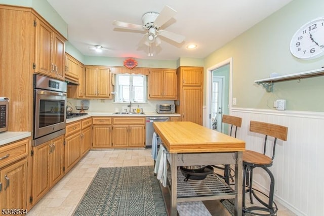 kitchen with sink, ceiling fan, and appliances with stainless steel finishes