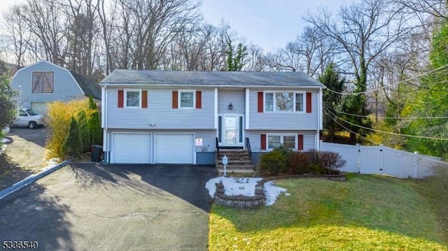 bi-level home with a garage and a front yard