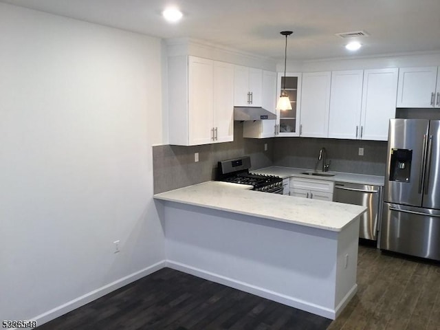 kitchen with white cabinetry, sink, kitchen peninsula, and appliances with stainless steel finishes