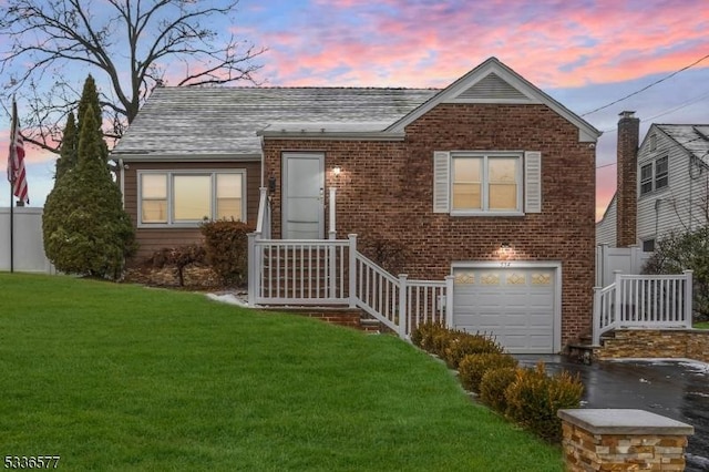 view of front of property featuring a garage and a yard