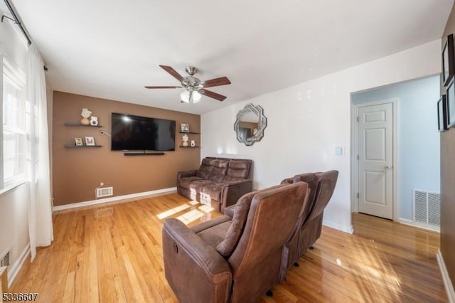 living room with light hardwood / wood-style flooring and ceiling fan