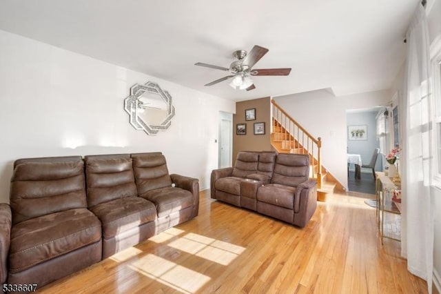 living room featuring light hardwood / wood-style flooring and ceiling fan