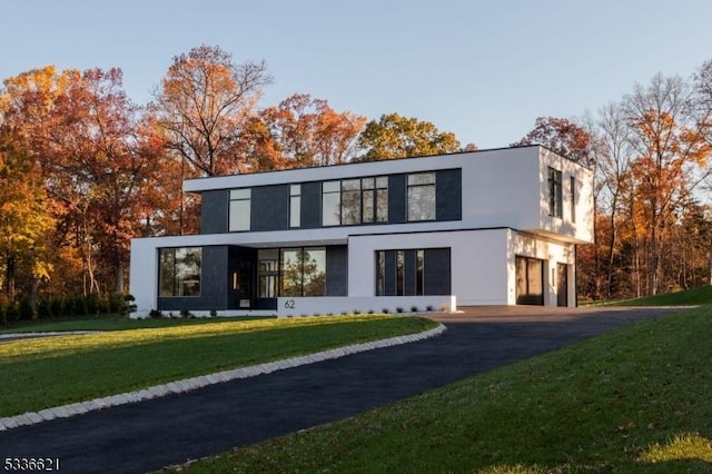 back of house featuring a yard and a garage