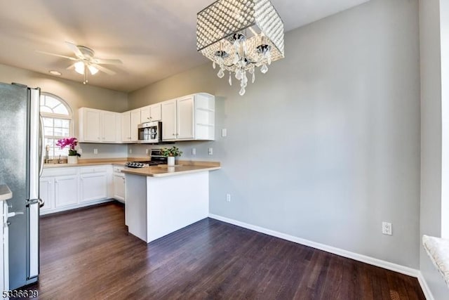 kitchen with dark wood-type flooring, white cabinetry, decorative light fixtures, kitchen peninsula, and stainless steel appliances