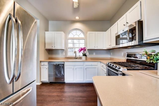 kitchen featuring stainless steel appliances, white cabinetry, sink, and dark hardwood / wood-style flooring