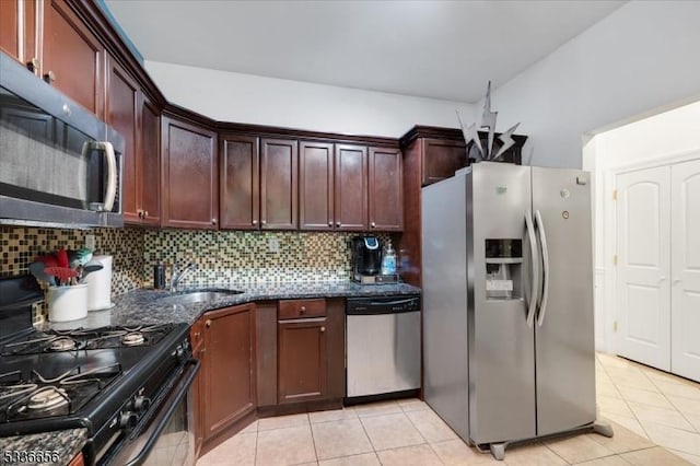 kitchen with sink, decorative backsplash, dark stone counters, and appliances with stainless steel finishes