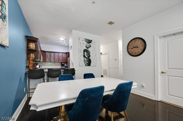 dining area featuring dark wood-type flooring