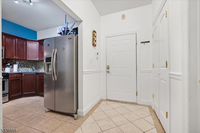 kitchen with stainless steel refrigerator with ice dispenser, light tile patterned floors, and backsplash