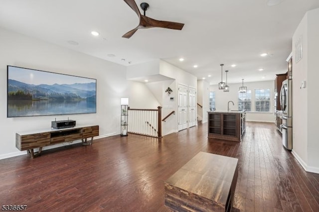 living room featuring ceiling fan, dark hardwood / wood-style flooring, and sink