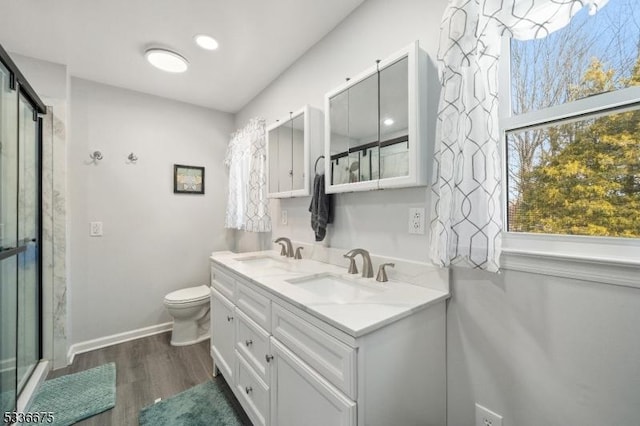 bathroom featuring vanity, toilet, a shower with door, and hardwood / wood-style floors