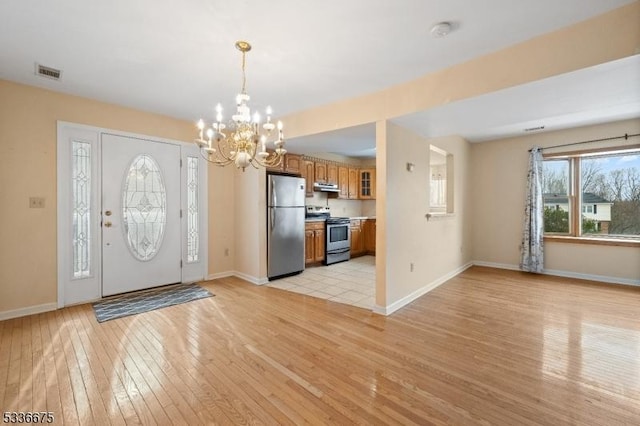 entrance foyer with light hardwood / wood-style flooring and a notable chandelier