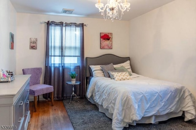 bedroom with an inviting chandelier and dark hardwood / wood-style floors