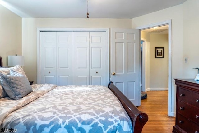 bedroom with light hardwood / wood-style floors and a closet