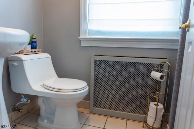 bathroom featuring tile patterned floors, toilet, and radiator