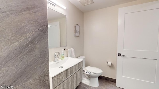 bathroom featuring tile patterned flooring, vanity, and toilet