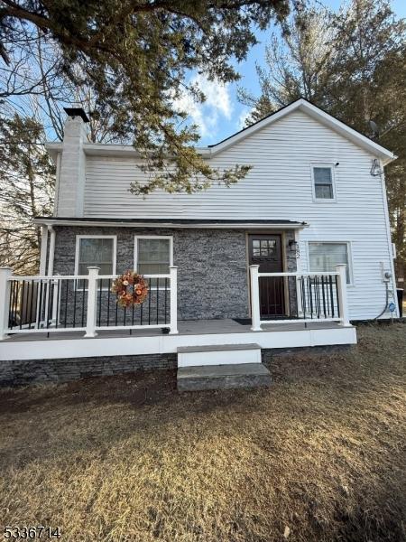 rear view of property with a lawn and covered porch