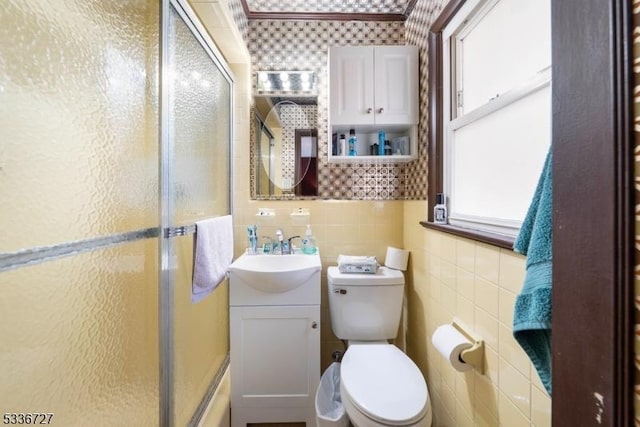 bathroom featuring vanity, toilet, tile walls, and walk in shower