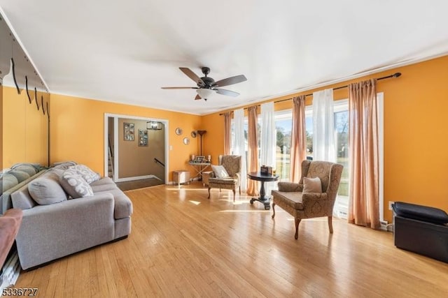 living room featuring light hardwood / wood-style flooring and ceiling fan