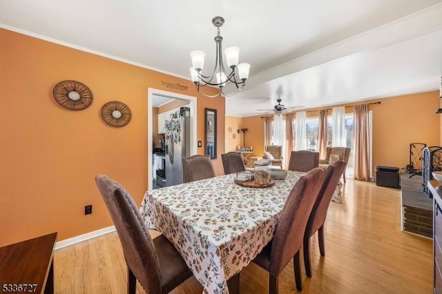 dining area with an inviting chandelier, ornamental molding, and light hardwood / wood-style floors