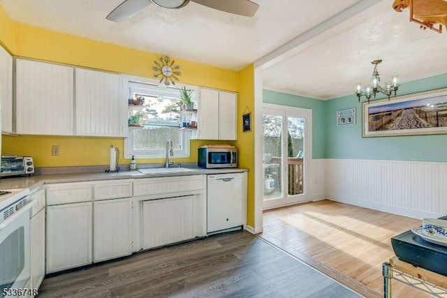 kitchen featuring hanging light fixtures, white cabinetry, hardwood / wood-style floors, and white appliances