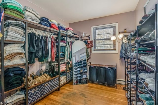 spacious closet featuring hardwood / wood-style floors and baseboard heating