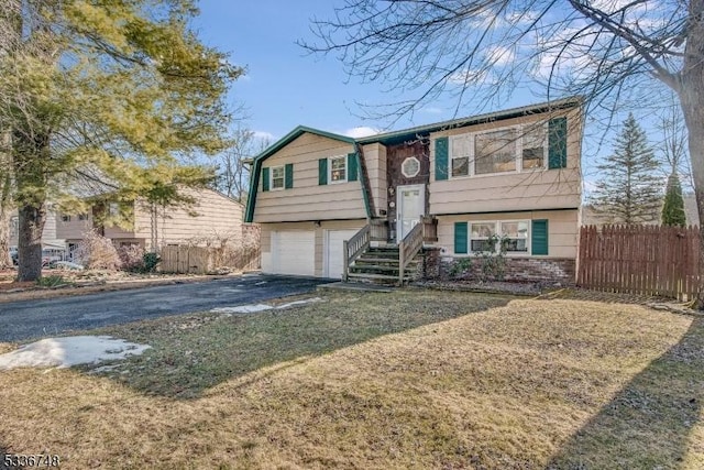 split foyer home with a garage and a front lawn