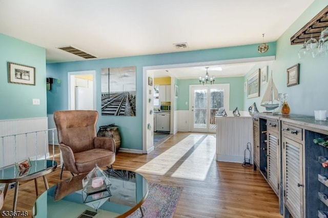 living area with a notable chandelier and light hardwood / wood-style flooring